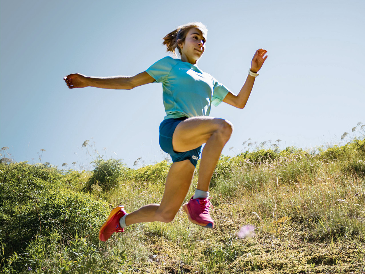 Mathilde in a high jump wearing the HOKA gear.