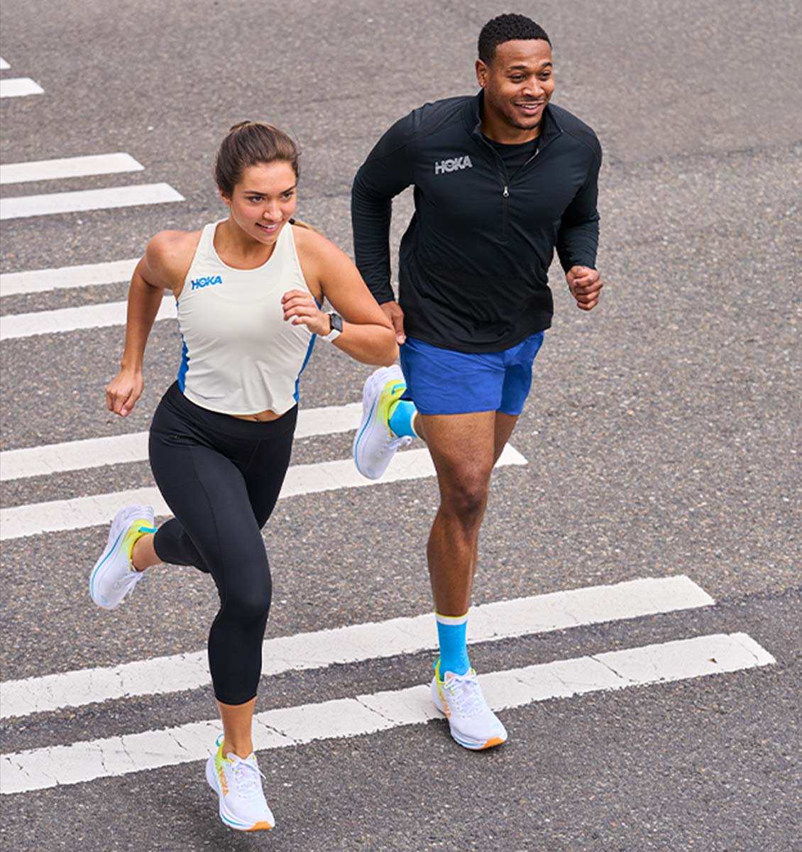Runnning couple wearing Bondi X shoes crossing the street