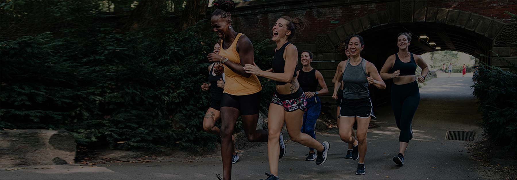 A group of people running through a city street.