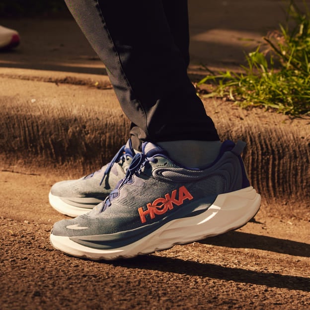 Gros plan des pieds d’un homme portant des chaussures HOKA.