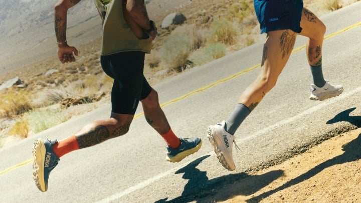 Deux coureurs portant des HOKA Challengers dans un terrain désertique.