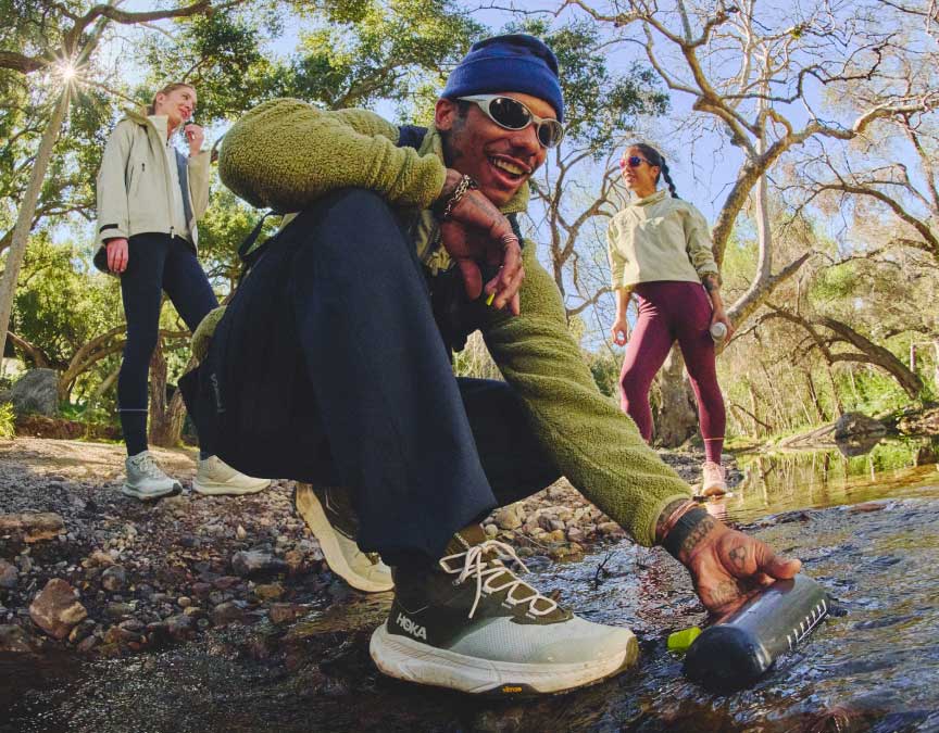 Homme agenouillé en tenue HOKA.