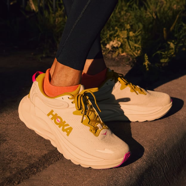 Gros plan des pieds d’une femme portant des chaussures HOKA.