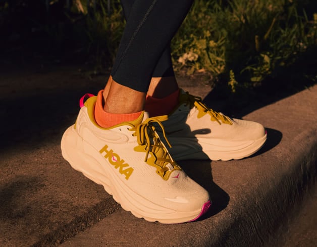 Gros plan des pieds d’une femme portant des chaussures HOKA.