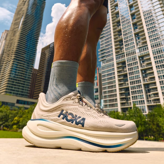 Gros plan des pieds d’un homme portant des chaussures HOKA.