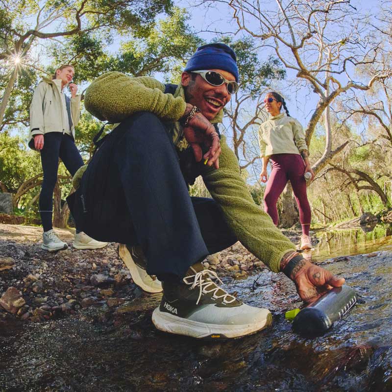 Homme agenouillé en tenue HOKA.