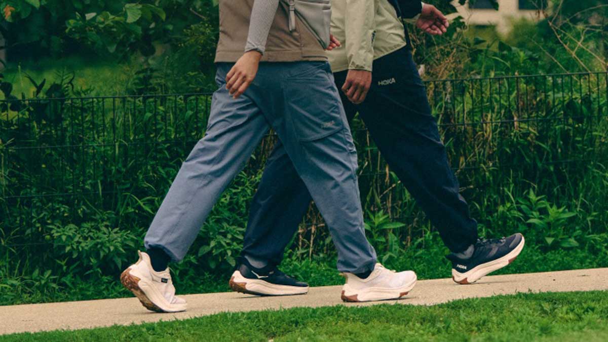 Deux personnes marchant en chaussures HOKA Transport.