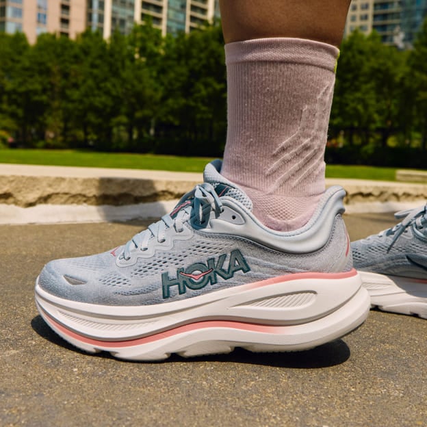 Gros plan des pieds d’une femme portant des chaussures HOKA.