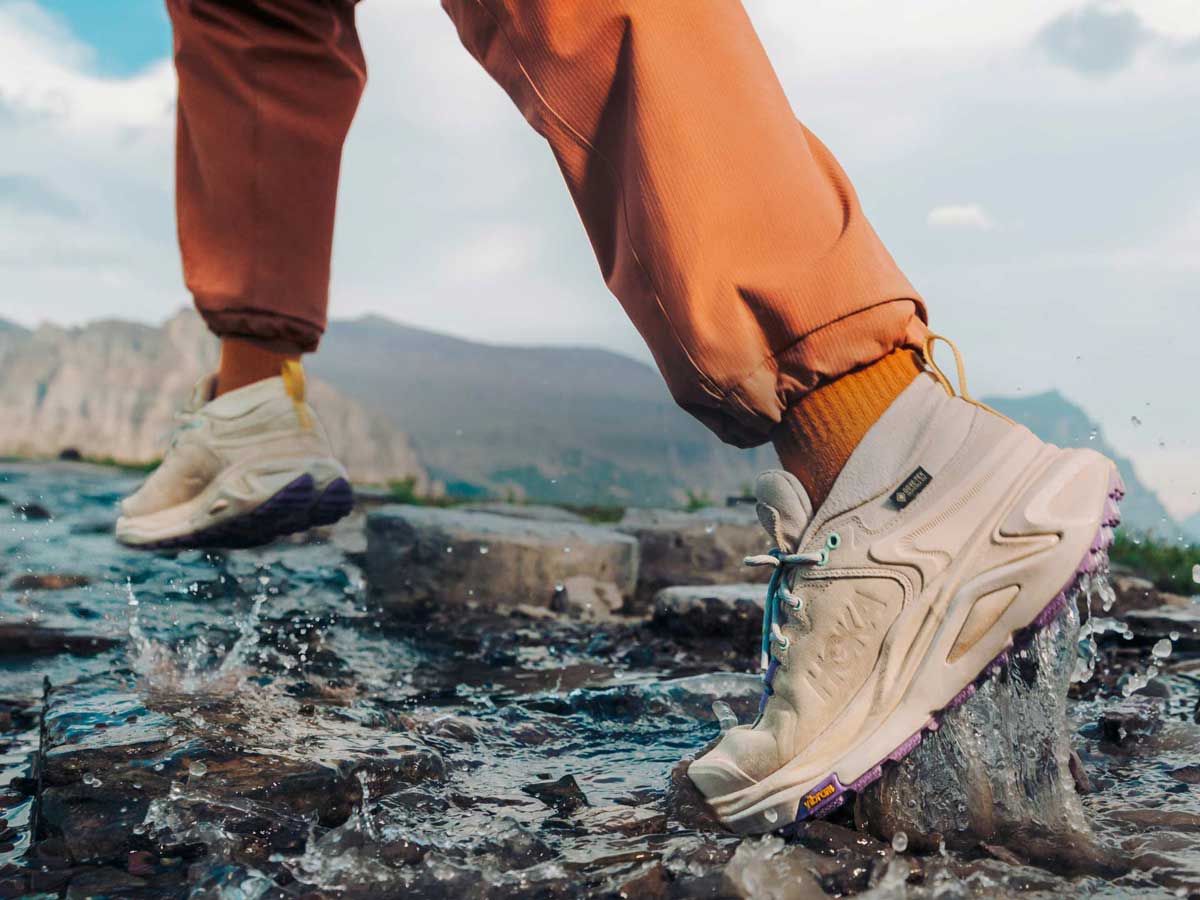 Personne marchant dans l’eau avec des chaussures HOKA.