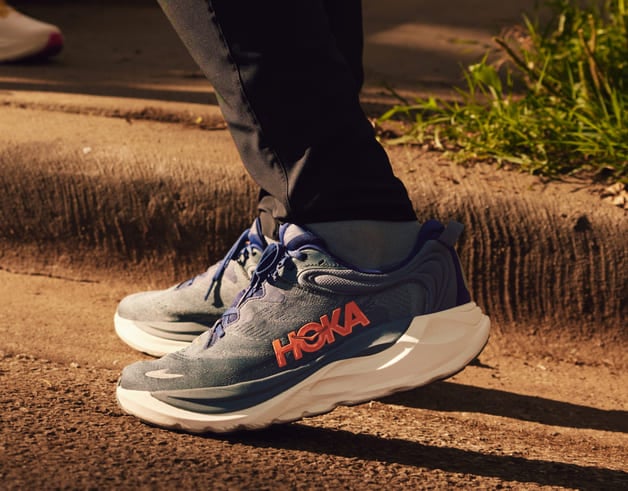 Gros plan des pieds d’un homme portant des chaussures HOKA.