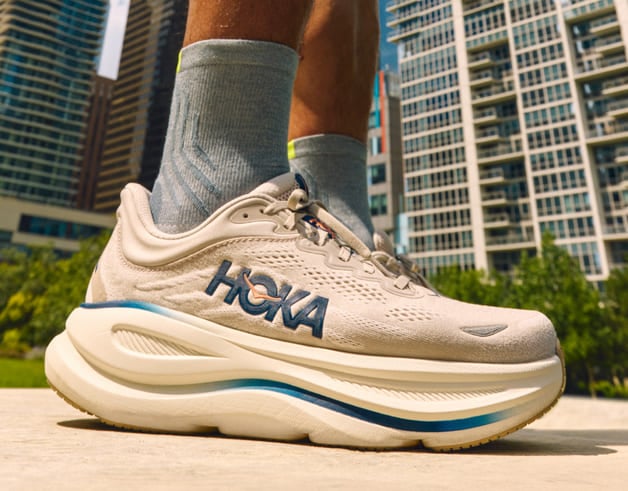 Gros plan des pieds d’un homme portant des chaussures HOKA.