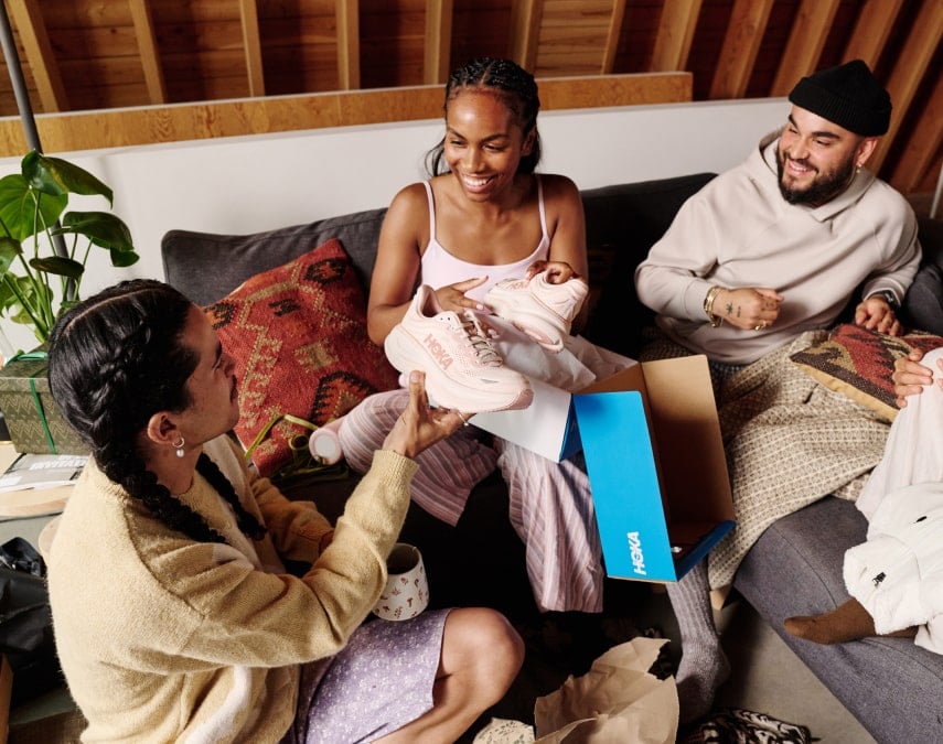 Deux personnes déballant une paire de chaussures HOKA.