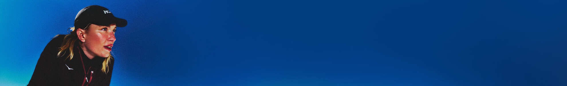 Photo d’une femme portant des vêtements HOKA avec un ciel bleu en arrière-plan