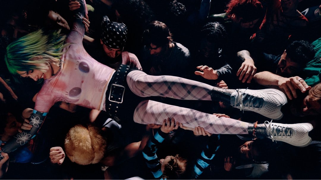 Mannequins surfant dans la foule lors d’un concert en portant des chaussures HOKA.