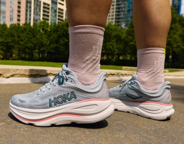 Gros plan des pieds d’une femme portant des chaussures HOKA.