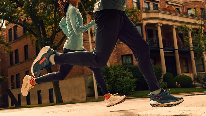 Deux personnes courant portant des chaussures HOKA